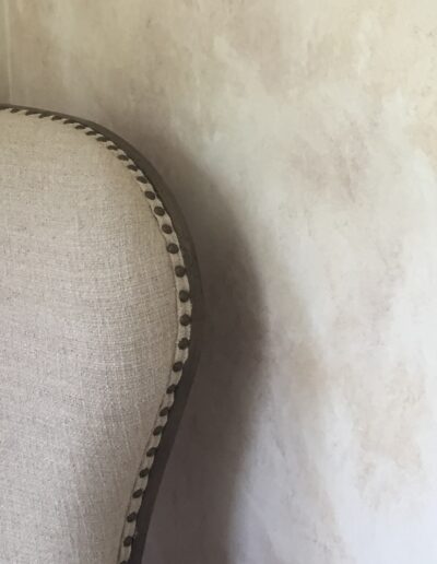 Fabric chair in front of textured wall